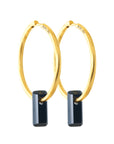 golden earrings, large hoops, black stone trough hoops, white background.