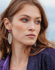 portrait, woman looking left, purple glitter jacket, large rubber earring.
