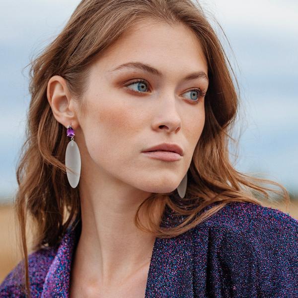 portrait, woman looking left, purple glitter jacket, large rubber earring.