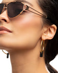 golden earrings, large hoops, black stone through hoops, white background, close-up