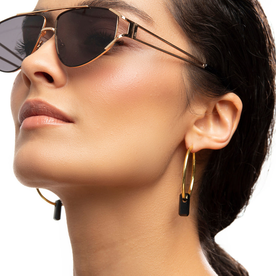 golden earrings, large hoops, black stone through hoops, white background, close-up