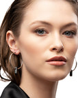 silver earrings, large hoop earrings, black stone through hoops, white background, close-up