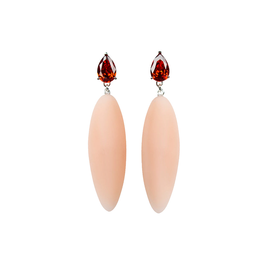 beige rubber, large earrings , tear shaped red stone, white background.